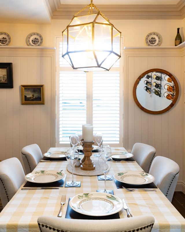 Bamburgh dining room with a lantern pendant, plates on the shelf and a check tablecloth